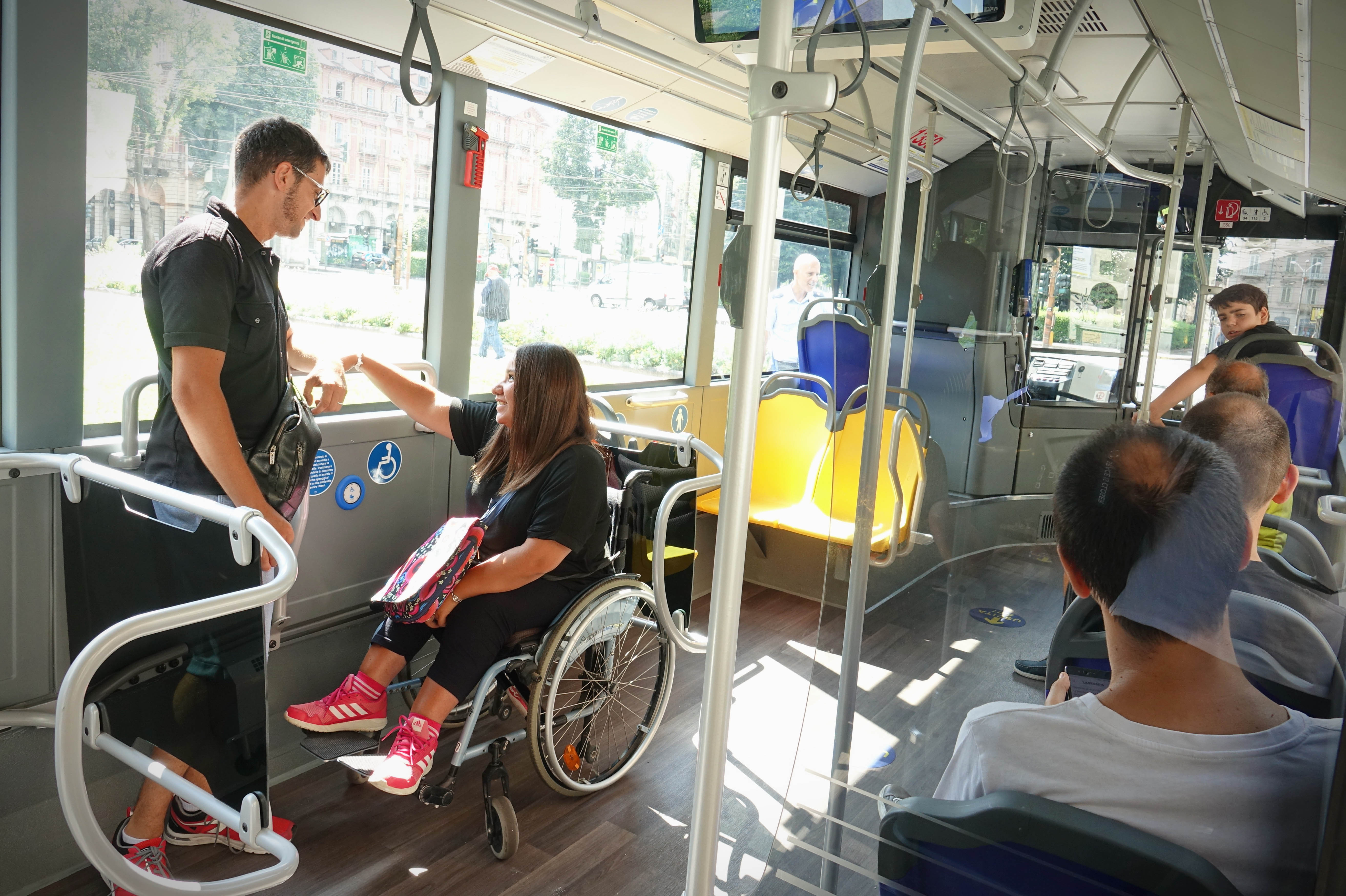 A woman using a wheelchair being supported by a man across from her. 