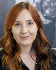 Kaley Day, a woman in a black shirt and red hair
