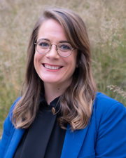 Lisa Didion, SPED Assistant Professor and KUCD Affiliated Professor, a caucasian woman with long, brown hair, circular-rimmed glasses, and a blue coat.