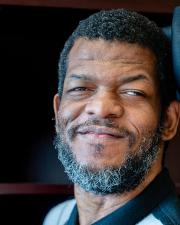 Askia Adams, a dark-skinned man with a graying beard.